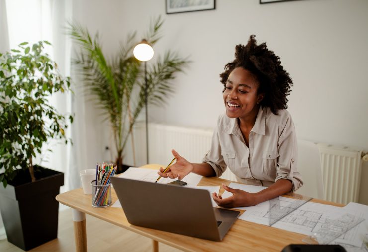 Image of happy black woman, smiling while speaking or chatting on video call in office.